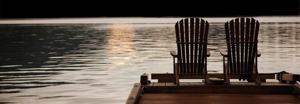 charitable donations for a relaxing retirement two Adirondack chairs looking out over the water